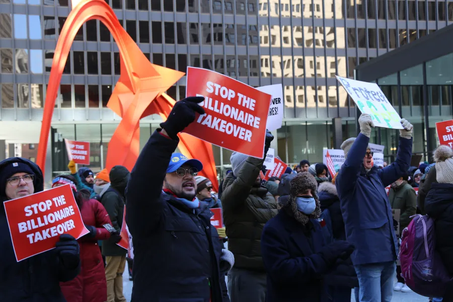 AFGE member holding a sign saying "Stop the billionaire takeover"